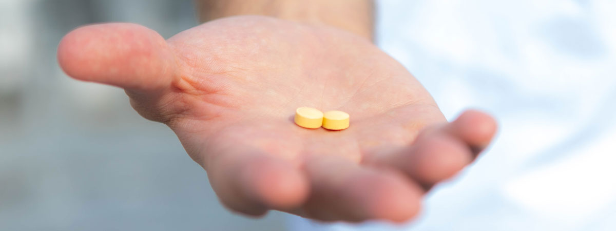 Hånd som rekker ut SOV-GODT melatonin sovetabletter.